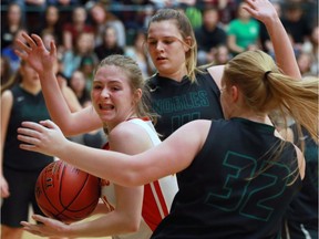 Sydney Charles, left, of Timmins gets double teamed by Madison Finnerty, centre, and Sydney Lavin of Belle River during the AA girls' OFSAA basketball tournament in Belle River, Ont., on Nov. 24, 2016.