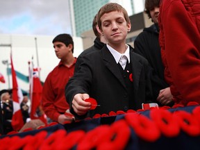 Local students place poppies in a box before shaking hands with local veterans at the 2011 Remembrance Day ceremony at the Cenotaph in Windsor in 2011.