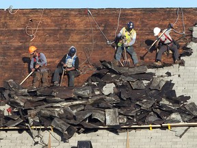 Roofers tear shingles off the former Our Lady of the Rosary Church at Riverside Dr. and Drouillard Rd. on Thursday, November 17, 2016 in Windsor, ON. Unseasonably mild temperatures made the job a bit easier.