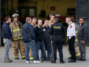 Workers at R.J. Cyr listen to an OPP officer, centre, as Tecumseh Fire officials joined with OPP to investigate at the Concession 8 plant just after 4 p.m. on Nov. 16, 2016. A man was taken to hospital by EMS paramedics following an industrial accident.