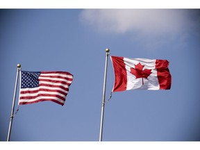 American and Canadian flag flying side by side. Photo by Getty Images.
