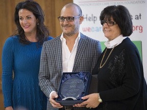 Liz Arkinstall, chair of the board for W.E. Care for Kids, left, presents Michael Piccioni and Joane Piccioni, brother and mother to Gino Piccioni of Timberland Homes. Gino Piccioni was recognized with the Founders Award for his contribution to the foundation at the wrapup event for W.E. Care of Kids at the Caboto Club on Nov. 18, 2016.