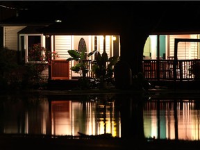 The lights from a house on Highway 20, south of LaSalle, are reflected in a flooded front lawn after torrential rain hit the area on Aug. 11, 2014.