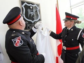 The LaSalle Police Honour Guard reveal a plaque during the dedication of a new memorial for Const. Robert Carrick at the LaSalle Police Headquarters in LaSalle on Aug. 22, 2014. Carrick was killed in the line of duty in 1969.