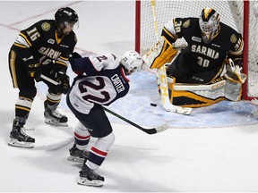 Windsor Spitfires Cole Carter fights off Sarnia Sting's Jordan Ernst for a shot on goaltender Aidan Huges during OHL action at the WFCU Centre in Windsor on Nov. 18, 2016.