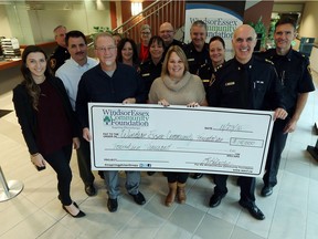 Ajsela Murselovic, Kevin Sivell, Shelley Atkinson and police Chief Al Frederick (front row, left to right) take part in a cheque presentation at police headquarters in Windsor on Nov. 23, 2016.