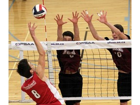 Leamington District High School's Allan Botham, middle, and Tyler Friesen try to block Stratford Central Secondary School's Kaleb Cole during OFSAA volleyball action at Academie Ste Cecile International School in Windsor on Nov. 25, 2016.