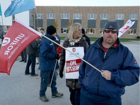 Picket line captain Patrick O'Neil with other members of Unifor Local 2458 strike in front of St. Joseph's Catholic High School on Clover Avenue on Wednesday November 9, 2016.