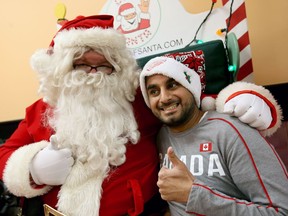 Deaf Santa (Scott Powers) signs with Gurjit Shergill, 29, at Cheese Wheelz on Ouellette Avenue on Nov. 17, 2016. Shergill used sign language to spell his name to interpreter Samantha Sesare, a student at Oakland College in Michigan.