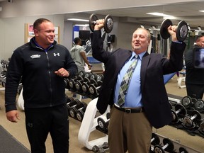 Luis Mendez. owner & operator, True Fitness Windsor, watches as Larry Horwitz, chair, Downtown Windsor BIA, lifts weights during a news conference on Nov. 25, 2016. Mendez wishes to expand his facilities to a second location in downtown Windsor. In doing so, Mendez plans to enhance True Fitness Windsor's current services with the addition of a massage therapist, chiropractor, and the inclusion of other health and wellness services.