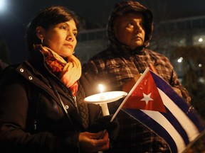 Blanca Linares, left, holds a Cuban flag along with Jose Parada during a candlelight vigil for late Cuban leader Fidel Castro at Dieppe Gardens Nov. 29, 2016.