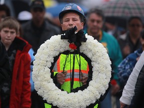 In this file photo, Ramiro Escoto carries a wreath as people march down Wyandotte Street East during the National Day of Mourning tribute, Sunday, April 28, 2013. Escoto's son, Takis Escoto, died after being injured on the job.