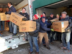 Dozens of volunteers, many with the Windsor Police Association, use their muscle to load 1,800 holiday gift boxes at Goodfellows on Park Street West Tuesday December 14, 2016. The boxes of food assist 34 different agencies. Windsor Police Association Administrator Ed Parent and Director Steve MacDonald were also on hand to donate $2,500 to Goodfellows GM Shannon Beaumont.