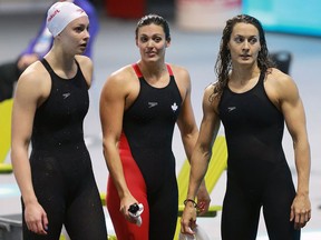 Team Canada's Penny Oleksiak, left, Michelle Williams and Sandrine Mainville are shown after being disqualified in the women's 4x100m freestyle during the 2016 FINA World Swimming Championships on Dec. 6, 2016, at the WFCU Centre in Windsor.