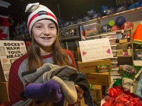 Sarah Lewis, 16, hands out socks and hats as part of her Socks Warm Your Heart campaign, while at the Street Help homeless centre, Tuesday, Dec. 13, 2016. This year Lewis has donated over 2000 pairs of socks and over $20,000 raising her 9-year total to 25,000 pairs of socks and over $80,000.