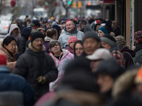 People line up along the 300 block of Ouellette Ave. for the Mikhail Holdings turkey giveaway in downtown Windsor, Friday, Dec. 23, 2016.