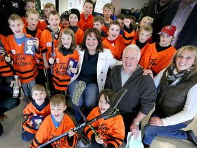 Carol Derbyshire, centre, of Hospice and Tim and Janet Beaulieu, right, co-chairs of Hockey for Hospice are surrounded by Tecumseh Orange Crush and Belle River Orange Flyers hockey players after they received trophies at Libro Complex Thursday Dec. 29, 2016.