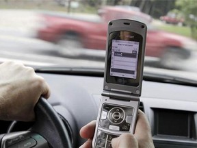 A cellphone is used in a car. (Associated Press files)