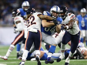 Zach Zenner #34 of the Detroit Lions battles for yardage against Cre'von LeBlanc #22 of the Chicago Bears and Adrian Amos #38 during third quarter action at Ford Field on December 11, 2016 in Detroit, Michigan.