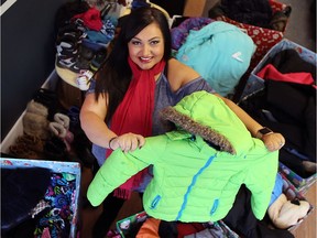 Marisa Guerrero, a company controller at JG Drywall and Painting in Windsor, poses on Dec. 2, 2016, with the dozens of coats and boots she has collected for families in need.