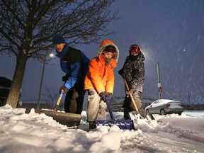 Brian Murtagh (left) and his kids Cohen, 8, and Tate, 11, shovel the driveway of their home on Luxury Avenue in Windsor's Riverside neighbourhoods on Dec. 11, 2016.