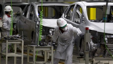 Employees work on cars at the Honda plant in the central Mexican state of Guanajuat.
