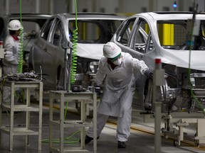 Employees work on cars at the Honda plant in the central Mexican state of Guanajuat.
