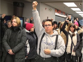 Michelle Griffiths, centre, and other members of CUPE Local 2974 hold their fists in the air following a rejection of the library board's "final offer" at Essex Centre Sports Complex on Dec. 13, 2016.