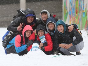 Members of the National Swim team from Taiwan pose for a photo after making a snowman on Ouellette Avenue in downtown Windsor, Ontario on December 11, 2016.   The team had finished their competition in the 2016 FINA World Swimming Championships and were exploring the city.