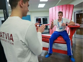 Team Latvia swimmers Daniils Bobrovs, left, films a video of teammate Nikolajs Maskalenko while he sits on a Muskoka chair at the 2016 FINA World Swimming Championships on Dec. 8, 2016, at the WFCU Centre in Windsor. Maskalenko has a YouTube channel and files videos for his subscribers.
