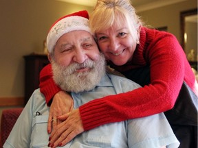 Richard Fox, left, is hugged by Sun Parlour Home manager of enrichment Sharon Beggs where entertainer Crystal Gage performed for residents Dec. 19, 2016.