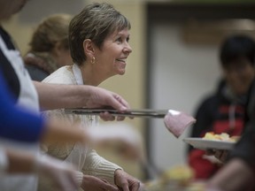 Volunteer Theresa Fortais, dishes out hot potatoes to those attending the Feeding Windsor program at St. Andrew's Presbyterian Church on Feb. 23, 2016.