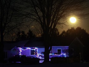 The moon rises above a home near Essex, Ont. on Thursday, Dec. 15, 2016.