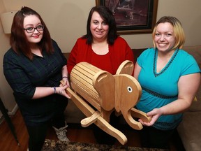 Rebekah Griffin, left, Mary Jo Jeindl and Kathleen Maika started a Facebook page called Pay it Forward where people give away free items, including this handmade rocking elephant.