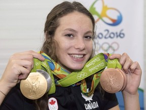 Canada's Penny Oleksiak, from Toronto, holds up her four medals, a gold, silver and two bronze, she won at the 2016 Summer Olympics during a news conference on Aug. 14, 2016 in Rio de Janeiro, Brazil.