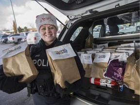 Const. Rebecca Tarabay, from Windsor Police Service, helps collect donations for the Stuff A Cruiser event at Real Canadian Superstore on Dougall Avenue, Saturday, Dec. 10, 2016.