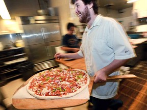 Nick Wilson of Sam's Pizzeria and Cantina in Windsor's west end prepares to put a pie in an oven. After months of competition, Sam's won the Pizza Fest at downtown Windsor cannabis lounge Higher Limits to decide the best pizza in the city. Photographed Dec. 14, 2016.