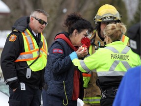 Emergency services personnel help a postal employee who suffered cuts to her face at the scene of a two car accident on Malden Road in LaSalle on Thursday, Dec. 22, 2016. Two people were taken to hospital.