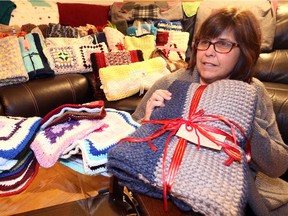 Denise Sauve of Warm Wishes Seniors Project, with 36 lap blankets, shawls and throws which were created for seniors at Brouillette Manor in Tecumseh Dec. 1, 2016.  The group hope to knit, crochet and sew a total of 60 lap blankets to be donated before Christmas Day.