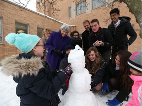 Ste. Cecile International School founder Therese Gadoury, second from left, watches students build a snowman at the South Windsor campus on Dec. 13, 2016.