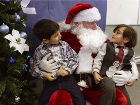 New Canadians Rafic Takche, 3, left, and Ali Olleik, 3, chat with Santa Paul Brownlie at New Canadians' Centre of Excellence.