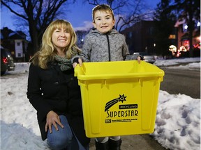 Seven-year-old Wilson Bortolin, right, and his mother Anastasia Adams display the "Golden Bin" presented to them by the Essex Windsor Solid Waste Authority for their exemplary recycling efforts.