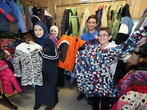 Iyah Ghemraoui, 12, left, Shahd Bleible, 13,  Zuhair Abdo, 13, and Bilal Tarabain, 13, participated in the eighth annual Coat Drive by the Windsor Muslim Community.  Students and staff delivered winter coats to the Coats for Kids trailer on Cantelon Drive on Dec. 7, 2016.