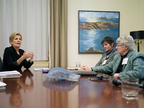 Amherstburg horse farmer Libby Keenan (CENTRE) speaks with Ontario Premier Kathleen Wynne (LEFT) about her soaring hydro bills at Toronto's Queen's Park, Wednesday January 18, 2017.