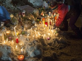 A young girl places a candle during a vigil on Jan. 30, 2017 in Quebec City. A shooting at a Quebec City mosque left six people dead on Jan. 29, 2017.