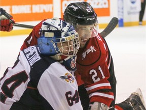 Owen Sound's Jonah Gadjovich, right, collides cheek-to-cheek with Windsor goalie Michael DiPietro during a game earlier this season.