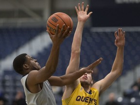 Windsor's Micqueel Martin, left, is defended by Queen's Tanner Graham during OUA men's basketball between the Windsor Lancers and the Queens Gaels at the St. Denis Centre on Jan. 8, 2017.