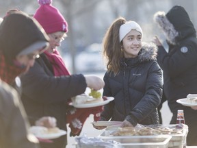 Jada Malott, 12, a Grade 7 student at St. John Vianney school, serves breakfast to striking library workers outside the Essex County Civic Centre on Jan. 6, 2017.  Malott paid for the food with her allowance while the Unemployed Help Centre prepared the wraps, fruit and bagels for the librarians who on their 196th day of picketing.