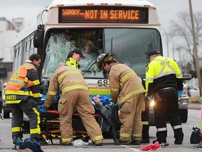 Windsor firefighters and paramedics help a man who was struck by a bus on Riverside Drive East at Moy Avenue on Jan. 24, 2017.