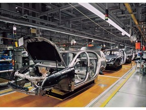 Car production line with unfinished cars in a row. Photo by Getty Images.